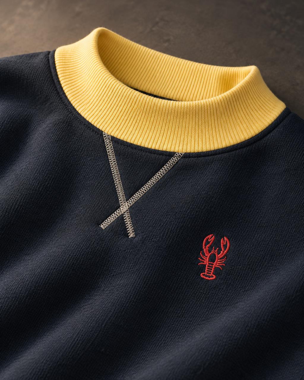 Navy sweatshirt with pale yellow ribbed collar, crossed V-stitch and red embroidered lobster