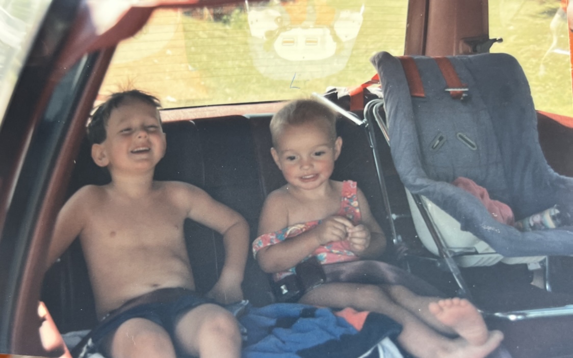 Kids in the back seat of a family car on a long road trip