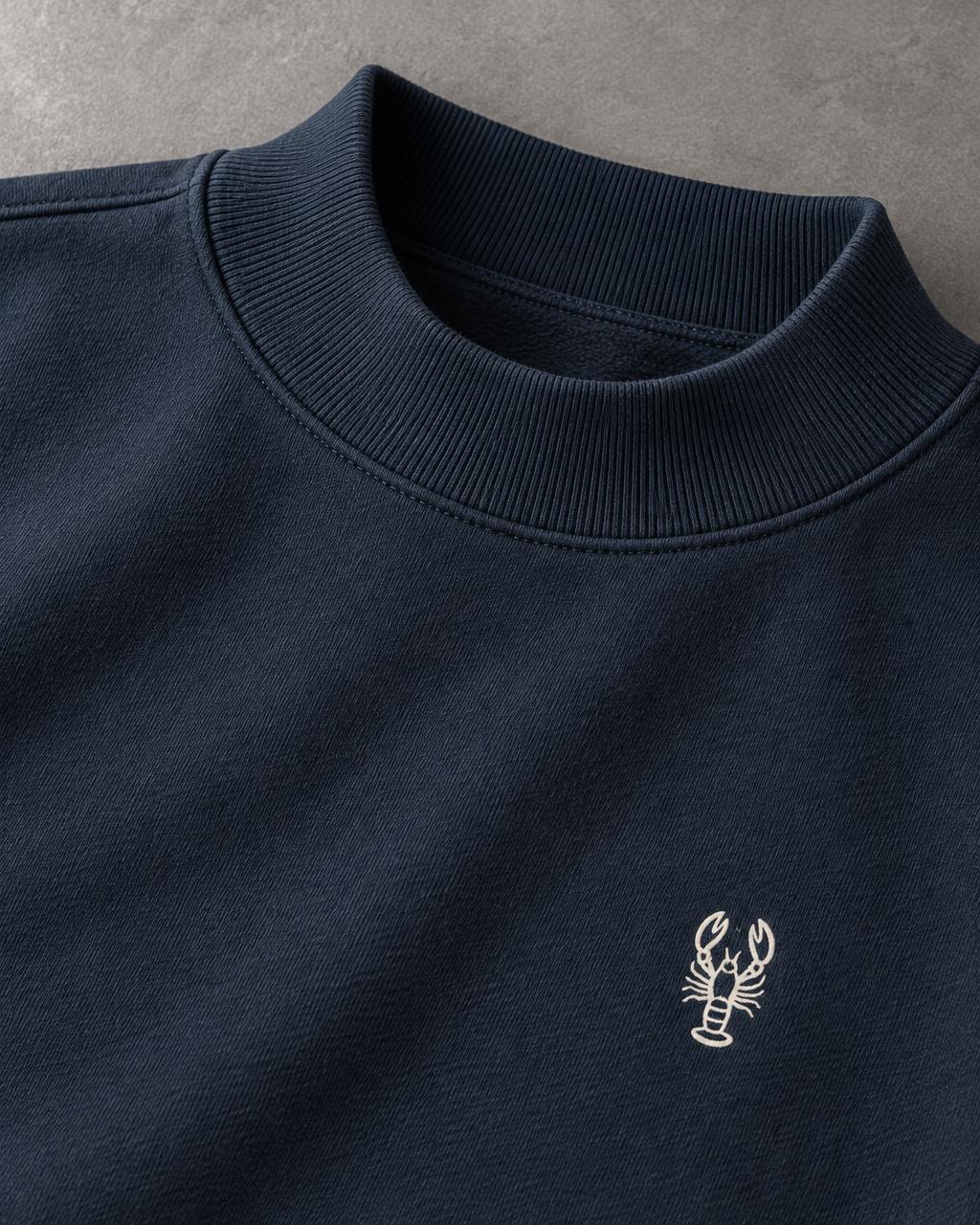 Close-up of the navy ribbed mock-neck collar and small white left-chest lobster