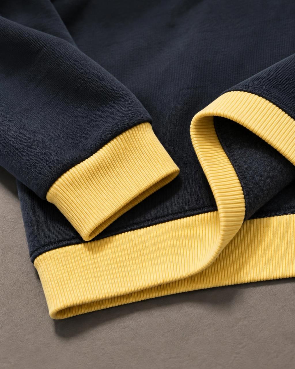 Pale yellow ribbed cuff and waistband with the navy hem turned back to show brushed fleece